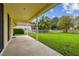 Large grassy backyard with covered patio and privacy fence at 2303 Hannah N Way, Dunedin, FL 34698