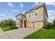 Two-story house with a red door, two-car garage and a neatly landscaped lawn at 2303 Hannah N Way, Dunedin, FL 34698