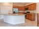 Open kitchen with granite countertops and wood cabinets at 1134 S Pointe Alexis Dr, Tarpon Springs, FL 34689