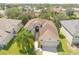 Aerial view of a single-Gathering home with a two-car garage and lush landscaping at 1134 S Pointe Alexis Dr, Tarpon Springs, FL 34689