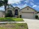 Beige house with two car garage and palm trees at 1134 S Pointe Alexis Dr, Tarpon Springs, FL 34689