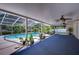 Spacious screened pool area with a blue carpet and ceiling fan at 4008 Greenmark Ln, Valrico, FL 33596
