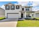 Two story house with white exterior, gray shutters, and two-car garage at 3729 Capri Coast Dr, Plant City, FL 33565