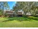 Large backyard with screened patio and mature oak tree at 29909 Baywood Ln, Wesley Chapel, FL 33543