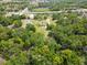 Expansive aerial view of home, outbuildings, nearby lake, and forested areas at 10223 Us Highway 301, Dade City, FL 33525