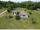 Another aerial view showcasing the home, mature trees, and lawn at 10223 Us Highway 301, Dade City, FL 33525