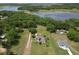 Aerial view of home with mature trees, grassy lawn, and lake nearby at 10223 Us Highway 301, Dade City, FL 33525