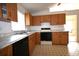 Efficient kitchen featuring wood cabinetry, black appliances, and a durable black and white tile floor at 10223 Us Highway 301, Dade City, FL 33525