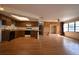 Open-concept living room featuring a brick fireplace, wood-look floors, and a view into the kitchen at 10223 Us Highway 301, Dade City, FL 33525