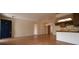 Bright living room with wood-look floors, view into kitchen and hall, and dark blue front door at 10223 Us Highway 301, Dade City, FL 33525