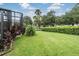 Spacious backyard with lush lawn and screened enclosure at 10735 Collar Dr, San Antonio, FL 33576