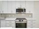 Modern kitchen featuring white cabinets, stainless steel appliances, and stylish backsplash at 201 27Th S St, St Petersburg, FL 33712