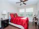 Bright bedroom with red bedding and a vanity area at 9107 Carolina Wren Dr, Tampa, FL 33626
