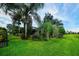 The manicured backyard features a healthy green lawn, palm trees, and shrubs at 331 Star Shell Dr, Apollo Beach, FL 33572