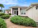 Front entrance of a house with brick walkway and well-maintained landscaping at 302 Caloosa Palms Ct, Sun City Center, FL 33573