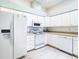 White kitchen with stainless steel appliances and light wood flooring at 13400 Norman Cir, Hudson, FL 34669