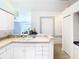 Kitchen with white cabinets, double sink, and view into living area at 13400 Norman Cir, Hudson, FL 34669