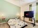 Bedroom with a flat screen TV and light green accent wall at 13400 Norman Cir, Hudson, FL 34669