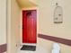 Red front door entrance with a birdcage and angel statue at 13400 Norman Cir, Hudson, FL 34669
