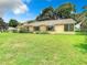 Back exterior view of the house showcasing a large lawn at 13400 Norman Cir, Hudson, FL 34669