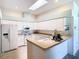 Bright kitchen featuring white cabinets, modern appliances, and laminate flooring at 13400 Norman Cir, Hudson, FL 34669