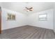 Simple bedroom with gray laminate wood flooring and two windows at 29171 Orva Dr, Punta Gorda, FL 33982