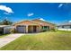 Ranch style home with grey garage door and green lawn at 29171 Orva Dr, Punta Gorda, FL 33982