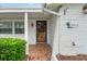 Front entrance with a metal security door and tiled porch at 7015 Flaggler Dr, Port Richey, FL 34668