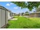 Spacious backyard with grassy area, shed, and partial view of neighboring homes at 7015 Flaggler Dr, Port Richey, FL 34668