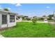 Spacious backyard with grassy lawn, a chain link fence, and a small tree at 7015 Flaggler Dr, Port Richey, FL 34668