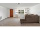 Living room with wood door, window, and brown sofa at 7015 Flaggler Dr, Port Richey, FL 34668