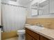 Bright bathroom with tub shower combo, wood vanity, and updated fixtures at 7015 Flaggler Dr, Port Richey, FL 34668
