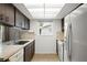 Efficient kitchen with dark cabinets, white appliances and tile floor at 7015 Flaggler Dr, Port Richey, FL 34668
