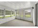 Cozy sunroom with multiple windows, carpet flooring, and access to backyard at 7015 Flaggler Dr, Port Richey, FL 34668