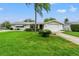 Ranch style home with a large green lawn and driveway at 7015 Flaggler Dr, Port Richey, FL 34668