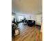 Bright living room with L-shaped sofa and wood-look floors at 10200 Gandy Blvd # 1116, St Petersburg, FL 33702