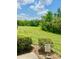 Well-manicured backyard featuring a 'Welcome' sign, lush lawn, and scenic pond backdrop at 761 Tremont Greens Ln # 61, Sun City Center, FL 33573