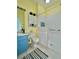 Bright bathroom with a blue vanity, tiled shower, and neutral walls at 761 Tremont Greens Ln # 61, Sun City Center, FL 33573