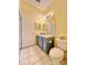 Bathroom area featuring a toilet, cabinet, and mirror with lighting at 761 Tremont Greens Ln # 61, Sun City Center, FL 33573