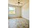 Bright bedroom with tile floors, a ceiling fan, and a large window offering outdoor views at 761 Tremont Greens Ln # 61, Sun City Center, FL 33573