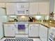Well-lit kitchen with white cabinets, granite counters, modern appliances, and decorative accents at 761 Tremont Greens Ln # 61, Sun City Center, FL 33573