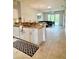 Bright kitchen featuring granite countertops and an island with seating, seamlessly flowing into the living area at 761 Tremont Greens Ln # 61, Sun City Center, FL 33573
