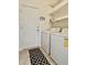 Laundry room with a washer, dryer, open storage shelving and a patterned black and white rug at 761 Tremont Greens Ln # 61, Sun City Center, FL 33573