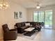 Warm living room featuring a brown sectional sofa and outdoor views at 761 Tremont Greens Ln # 61, Sun City Center, FL 33573