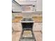 Open oven with range, microwave and speckled granite countertops in a bright, well-equipped kitchen at 761 Tremont Greens Ln # 61, Sun City Center, FL 33573