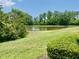 Scenic view of a serene pond surrounded by lush greenery and trees on a bright day at 761 Tremont Greens Ln # 61, Sun City Center, FL 33573