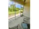 Relaxing screened porch featuring chairs and a decorative table with a view of the beautiful pond at 761 Tremont Greens Ln # 61, Sun City Center, FL 33573