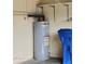 Water heater in the garage with a blue recycle bin at 761 Tremont Greens Ln # 61, Sun City Center, FL 33573