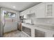 Outdoor kitchen with white cabinets, granite countertops, and stainless steel sink at 2707 W Leroy St, Tampa, FL 33607