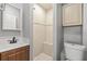 Small bathroom with shower, toilet, and vanity with wood cabinets at 2707 W Leroy St, Tampa, FL 33607